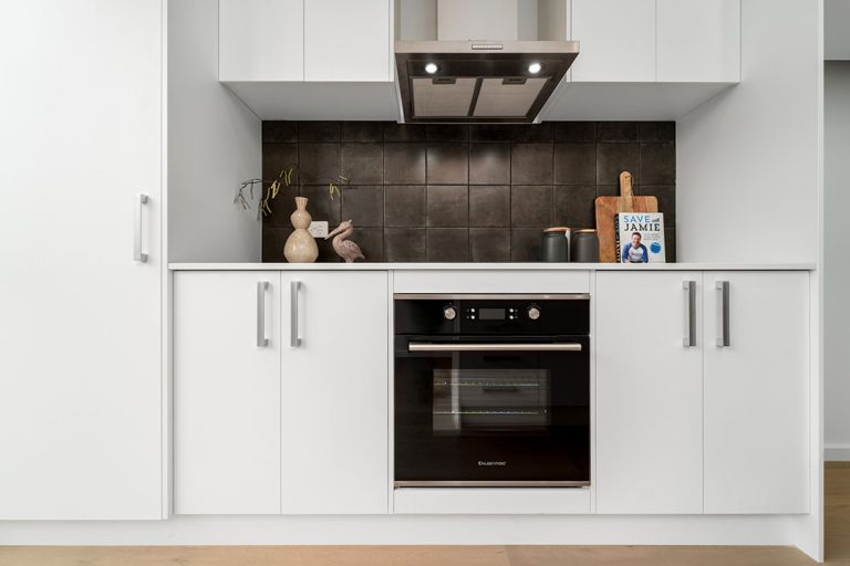 Centenary, Seaford: a kitchen with white cabinets and a stove