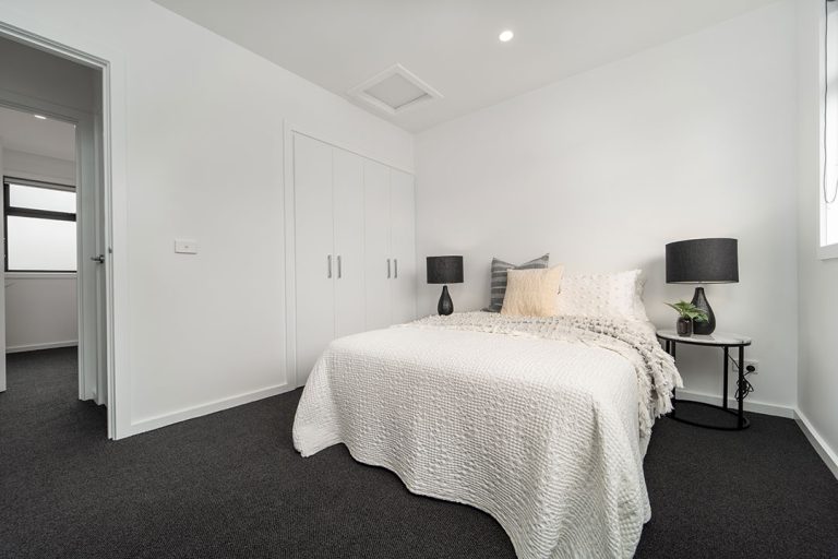 Centenary, Seaford: a bed with black lamps and a white wall