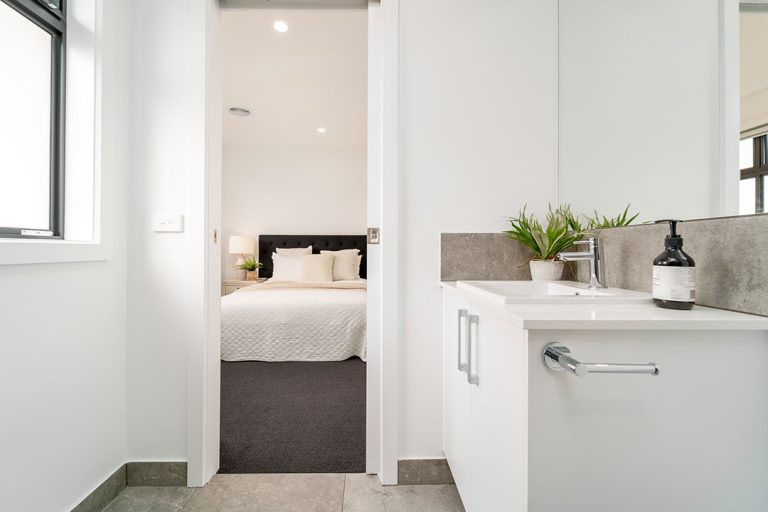 Centenary, Seaford: a white bedroom with a bed and sink