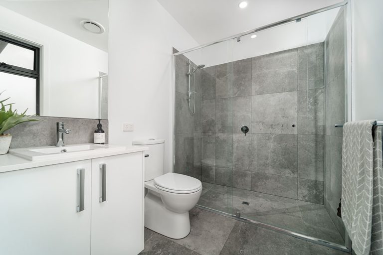 Centenary, Seaford: a bathroom with a glass shower and sink